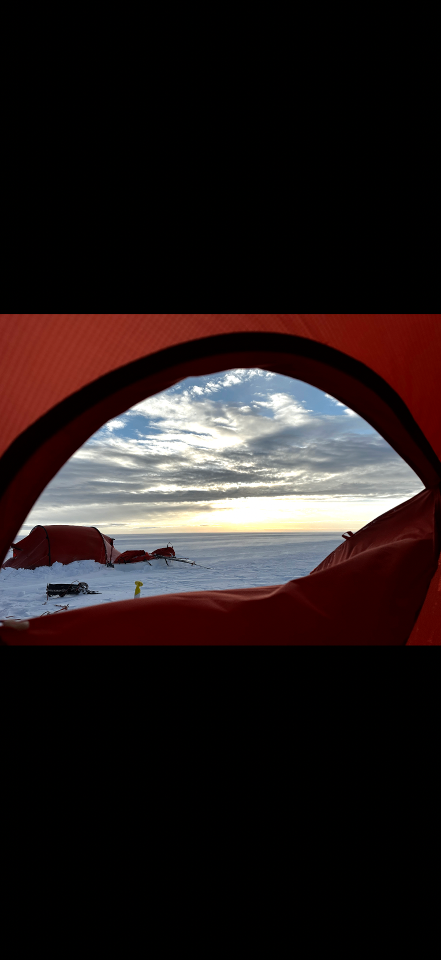 Utsikt fra teltåpningen mot solnedgang over innlandsisen